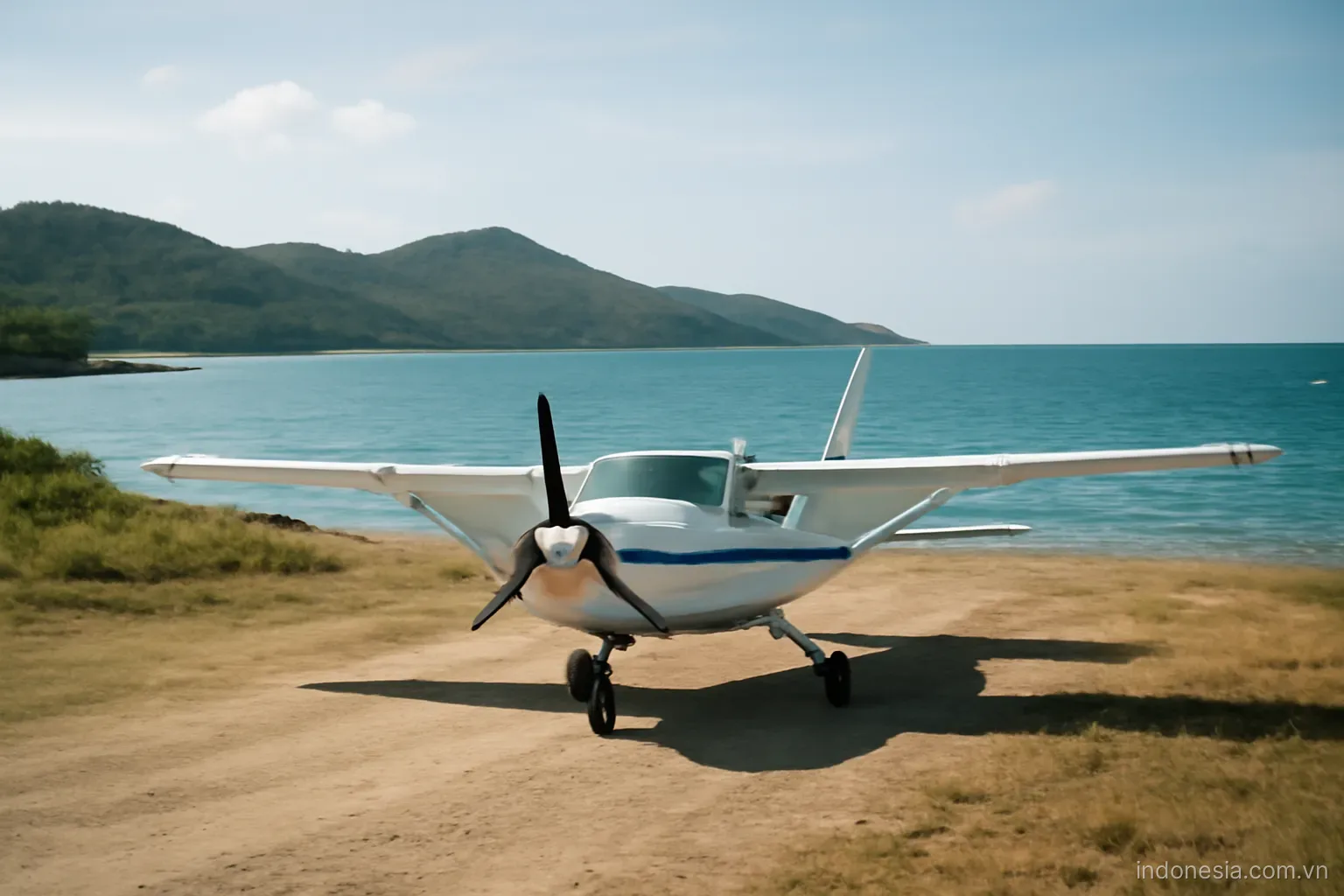 A propeller aircraft parked on a small island airstrip with sea and hills behind, wide view, no text