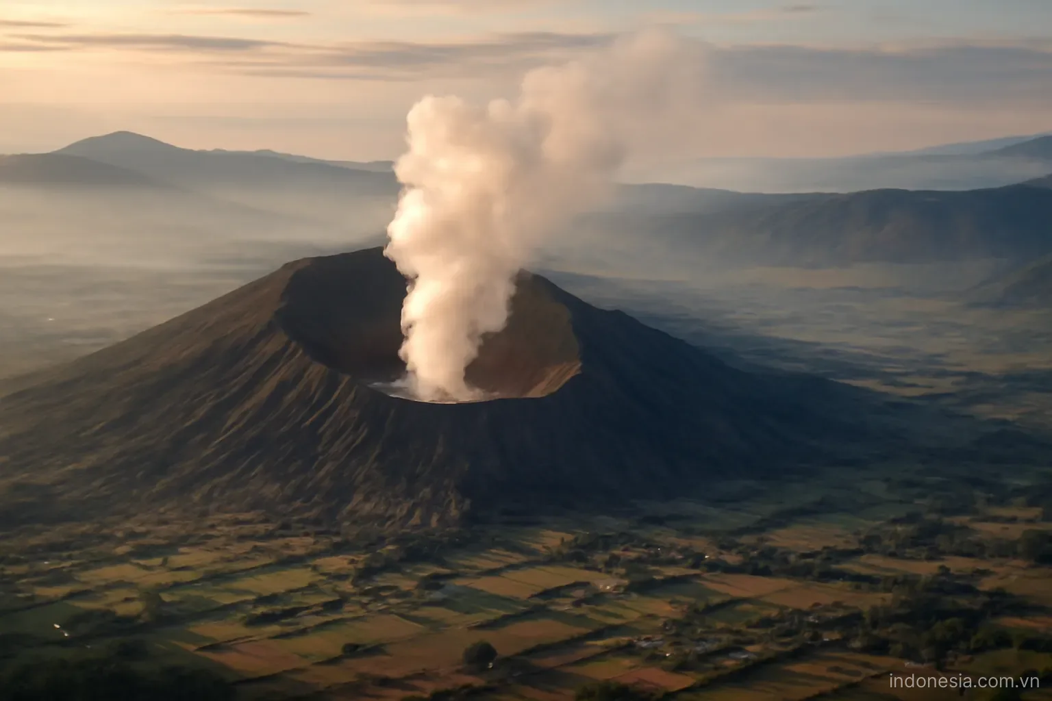 A steaming volcanic crater above a valley of farmland and small settlements, early morning light, wide view, no text